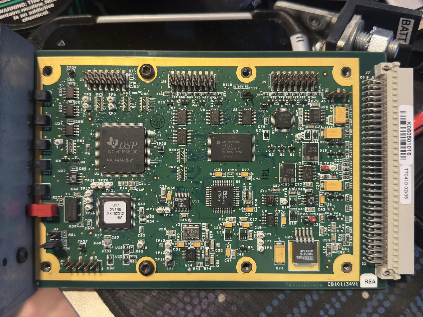MASTR III P25 DSP controller card with its protective cover removed, exposing the DSP processor, memory, test points, connectors, and other PCB components